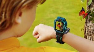 Anak kecil tersenyum memakai smartwatch berwarna cerah, tampak senang dan terhubung.