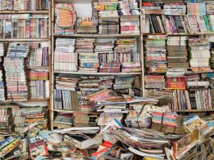 Gambar tumpukan buku bekas atau sudut nyaman di toko buku bekas.