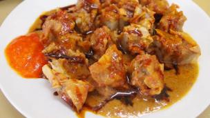Piring berisi siomay dan batagor lengkap dengan bumbu kacang, jeruk limau, dan kecap manis, suasana menggugah selera.