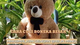 Boneka beruang besar sedang dimasukkan ke mesin cuci jumbo di Lovely Laundry.