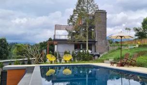 Villa modern dengan kolam renang infinity yang menghadap perkebunan teh hijau di Puncak Bogor.