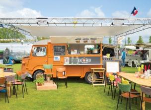 Berbagai food truck berwarna-warni berjajar di sebuah event outdoor dengan pengunjung yang ramai.