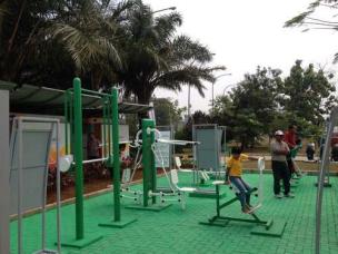 Orang berolahraga di gym yang sederhana namun bersih, atau di outdoor gym di taman kota.