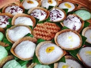 Aneka kue basah tradisional Indonesia (klepon, serabi, lemper, lapis legit) ditata cantik di piring atau nampan.