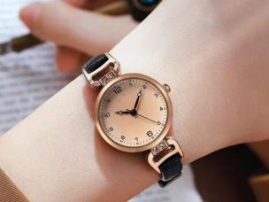 Jam tangan vintage dengan tali kulit yang usang namun berkarakter, diletakkan di samping buku tua.