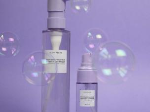 Gambar botol Glow Recipe Blueberry Bounce Gentle Cleanser dengan estetika cerah, ceria, dan bersih, menonjolkan bahan dasar buah dan sifat melembapkannya, dengan latar belakang samar Senayan City, Jak