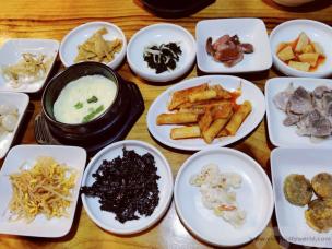 Meja makan dengan hidangan Korean BBQ, banchan, dan kimchi.