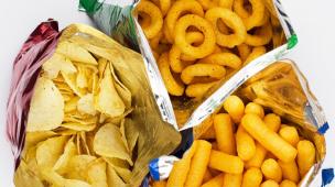 Gambar beberapa bungkus snack ekstrudat dengan bentuk berbeda-beda seperti cincin dan bola, sebagian isinya tumpah ke mangkuk.