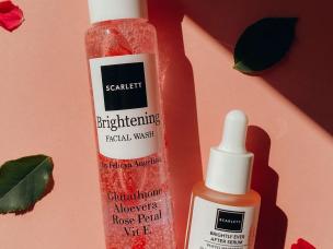 Gambar tube Scarlett Whitening Brightly Ever After Facial Wash dengan estetika cerah bertema pink, mungkin dengan efek kilau samar atau ilustrasi vitamin, menonjolkan sifat pencerahannya, dengan latar