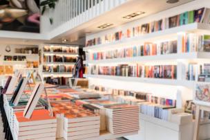 Gambar interior toko buku dengan bagian buku dan produk gaya hidup.