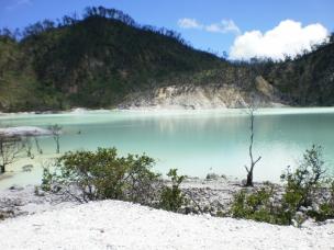 Pemandangan danau belerang Kawah Putih dengan air berwarna kehijauan.