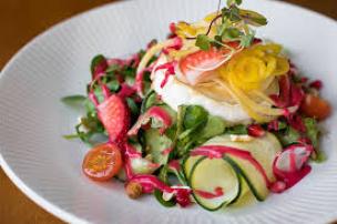 Piring berisi salad segar dan hidangan vegetarian di sebuah kafe sehat.