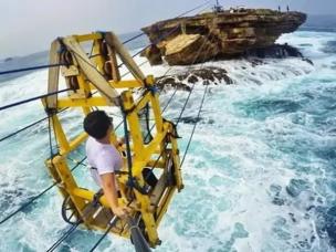Gambar gondola tradisional menyeberang ke pulau berbatu di Pantai Timang.