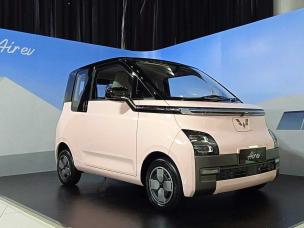 Gambar Wuling Air EV diparkir di stasiun pengisian daya EV atau tempat perkotaan modern di Kelapa Gading, Jakarta Utara, menonjolkan desain unik dan sifat ramah lingkungannya.
