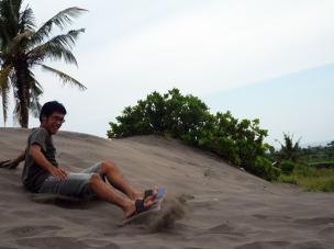 Gambar Gumuk Pasir Parangkusumo dengan orang-orang bermain sandboarding.