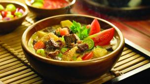 Semangkuk soto Betawi dengan kuah kental dan potongan daging.