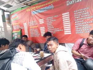 Sekelompok mahasiswa sedang nongkrong di warmindo dengan Indomie dan minuman.