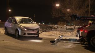 Mobil derek sedang menarik mobil mogok di jalan raya yang sepi di malam hari.
