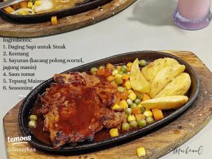 Piring berisi potongan steak medium rare dengan sayuran dan saus.