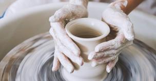 Orang sedang membuat keramik di studio pottery menggunakan roda putar.