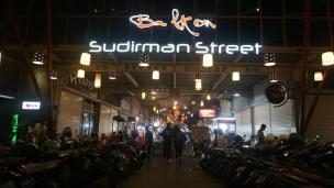 Suasana malam hari di Sudirman Street Day & Night Market dengan lampu-lu.