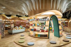 Gambar interior toko buku anak-anak yang penuh warna dengan buku dan mainan.