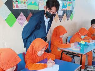 Gambar sekelompok siswa bekerja bersama di meja, sedang merancang model atau prototipe.