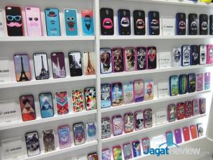 Display berbagai casing handphone berwarna-warni dan screen protector di toko aksesoris.