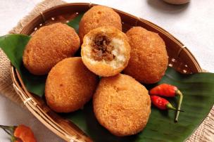 Berbagai jenis camilan tradisional Indonesia seperti combro, misro, dan kue pancong tersaji di nampan.