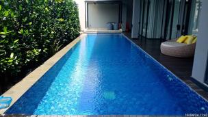 Gambar kolam renang infinity yang bersih dengan pemandangan kota di kejauhan.