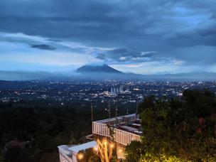 Pemandangan city light Bogor dari ketinggian villa di malam hari dengan lampu-lampu kota yang berkilauan.