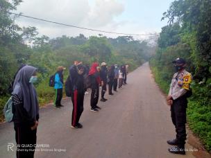 Gambar siswa-siswi sedang melakukan kegiatan hiking di jalur alam, mengenakan backpack dan topi.