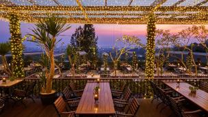 Pasangan menikmati makan malam dengan city light Bandung di The Valley Bistro Cafe.