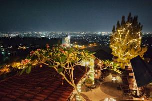 The Valley Bistro Cafe dengan pemandangan city light Bandung di malam hari.
