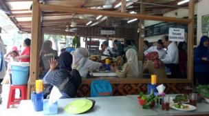 Sejumlah orang mengantre panjang di depan kedai sate tradisional.