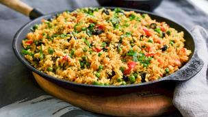 Sepiring nasi goreng dengan topping melimpah yang disajikan di warung pinggir jalan.