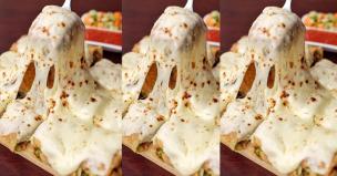 Potongan martabak manis dengan topping keju mozzarella yang meleleh dan mulur.