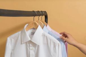 Kemeja putih disetrika rapi dan digantung di hanger mewah di laundry The Trans Luxury Hotel.