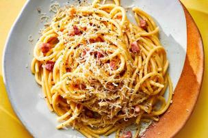 Piring berisi pasta carbonara yang creamy dan lezat di restoran Italia.