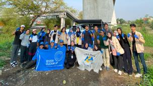 Relawan membersihkan sampah di pinggir sungai Bandung dalam kegiatan komunitas.