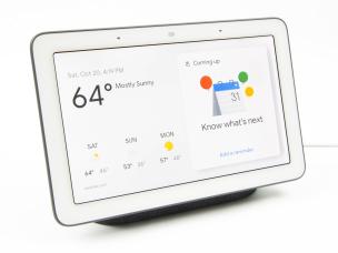 Perangkat smart home hub di atas meja, dengan layar sentuh menampilkan antarmuka kontrol perangkat rumah pintar.