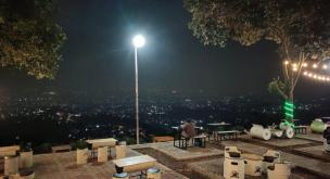 Suasana cafe rooftop di malam hari dengan city light Bandung.