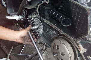Mekanik sedang membersihkan komponen CVT motor matic.
