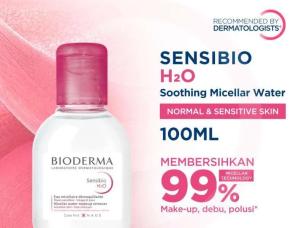 Gambar botol Bioderma Sensibio H2O dengan tutup merah muda khasnya, dengan tetesan air pada permukaan kulit yang bersih dan tenang, menonjolkan pembersihan lembutnya untuk kulit sensitif, dengan latar