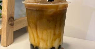 Gelas es kopi susu gula aren dengan topping boba dan cream cheese yang menggoda.