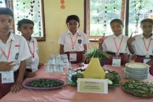 Siswa-siswa sedang praktik di bengkel otomotif atau dapur kuliner sekolah, memakai seragam kejuruan.