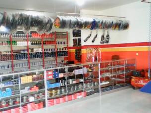 Berbagai suku cadang motor di rak toko