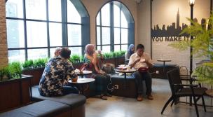 Orang-orang berdiskusi di sebuah co-working space yang modern dan nyaman.