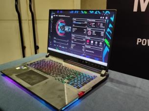 Gambar ASUS ROG Strix Scar 17 di meja gaming, menyoroti desain agresif dan potensi ventilasi pendingin/RGB yang terlihat, dengan latar belakang Central Park Mall Jakarta Barat.